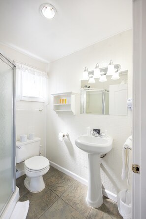 A bathroom with a toilet, sink, and mirror.