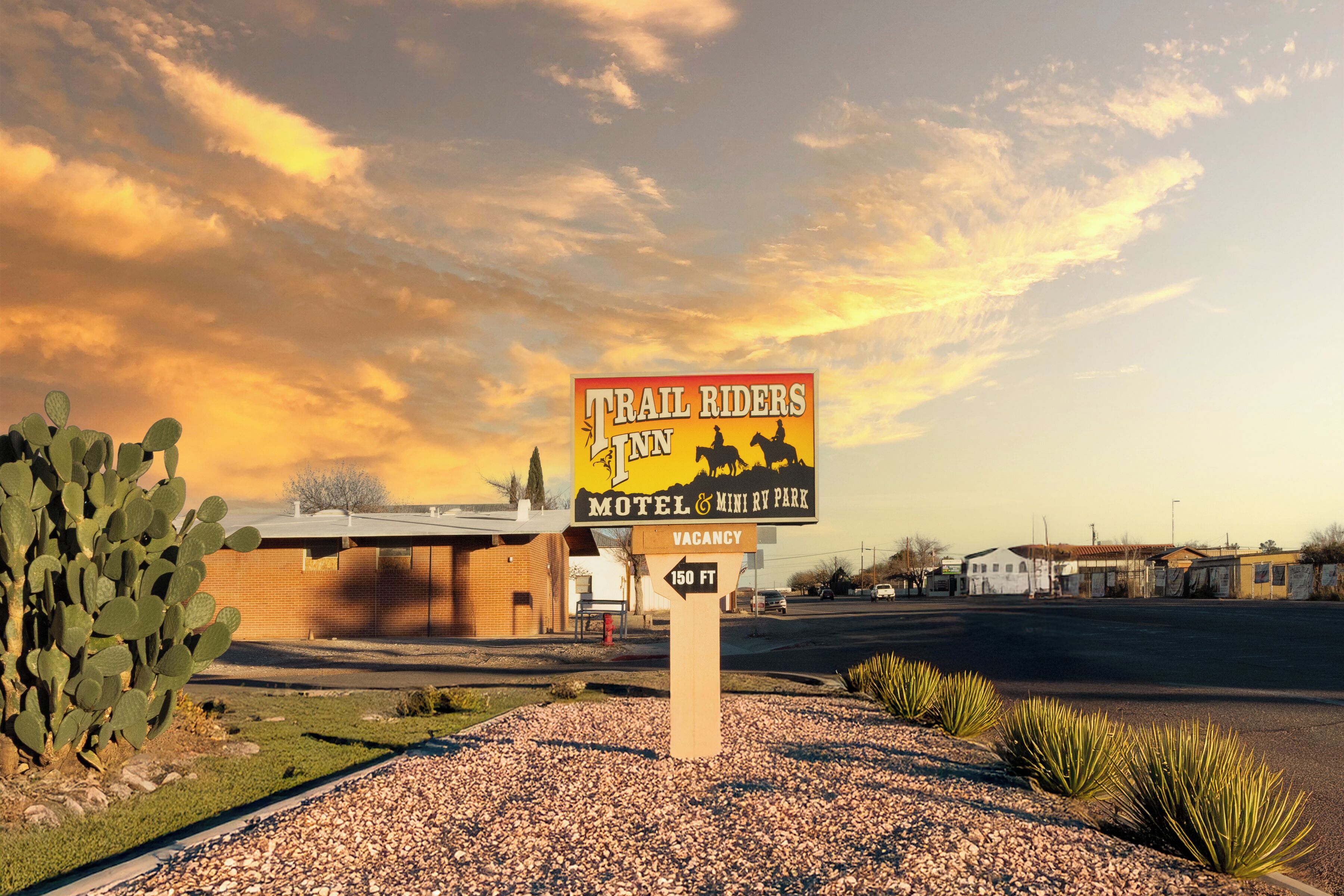 Letrero del motel Trail Riders Inn & Mini Parque para Autocaravanas con aviso de habitaciones disponibles.
