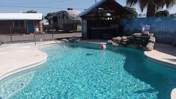 Una piscina al aire libre de temporada, sombrillas