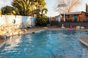 Una piscina al aire libre de temporada, sombrillas