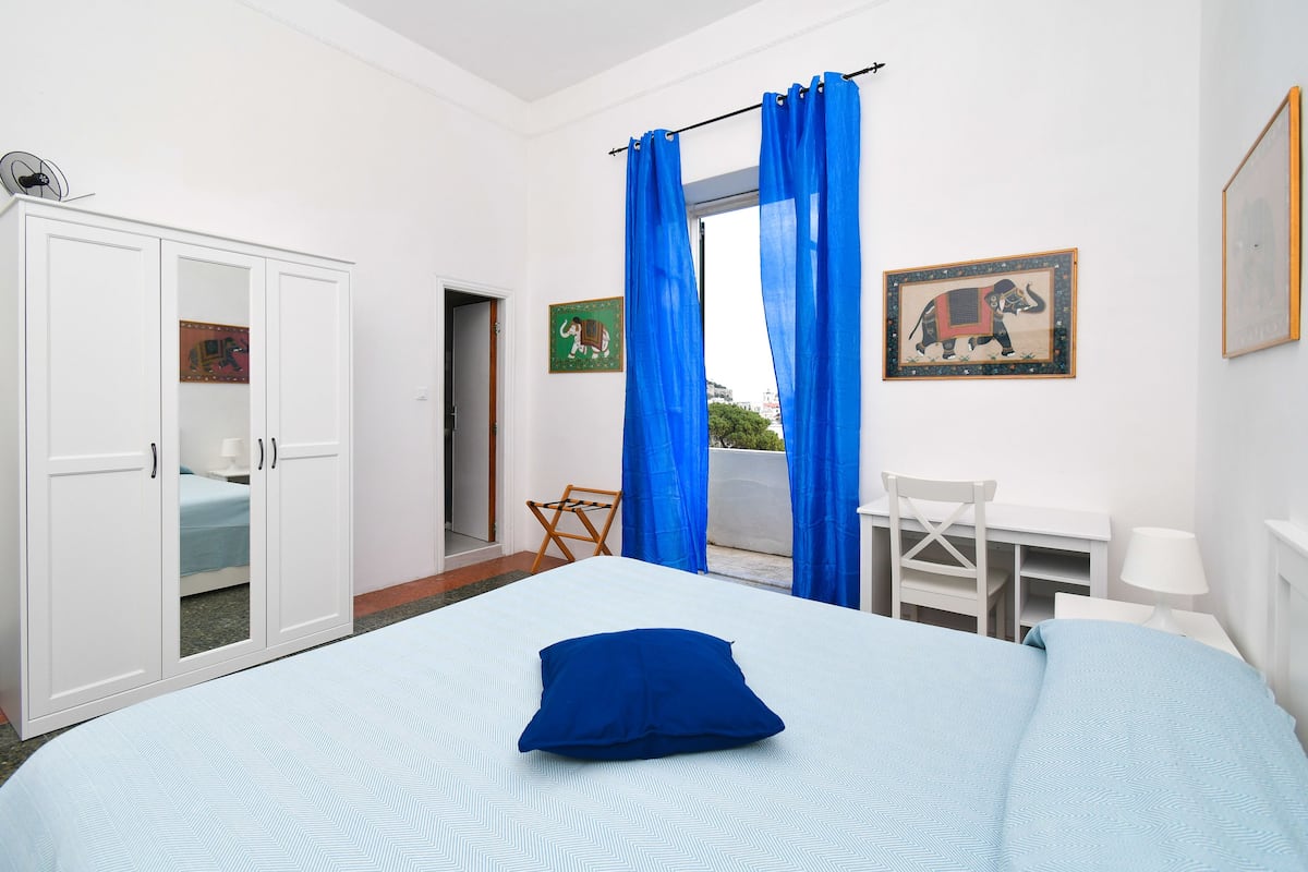 Ein Schlafzimmer mit Bett, Schreibtisch, Stuhl und Kleiderschrank.