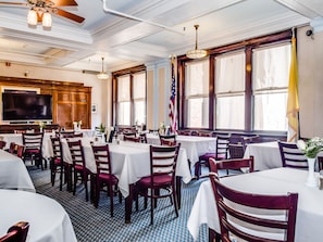 Enjoy meals in this elegant dining area with round tables, comfortable chairs, and a high ceiling.