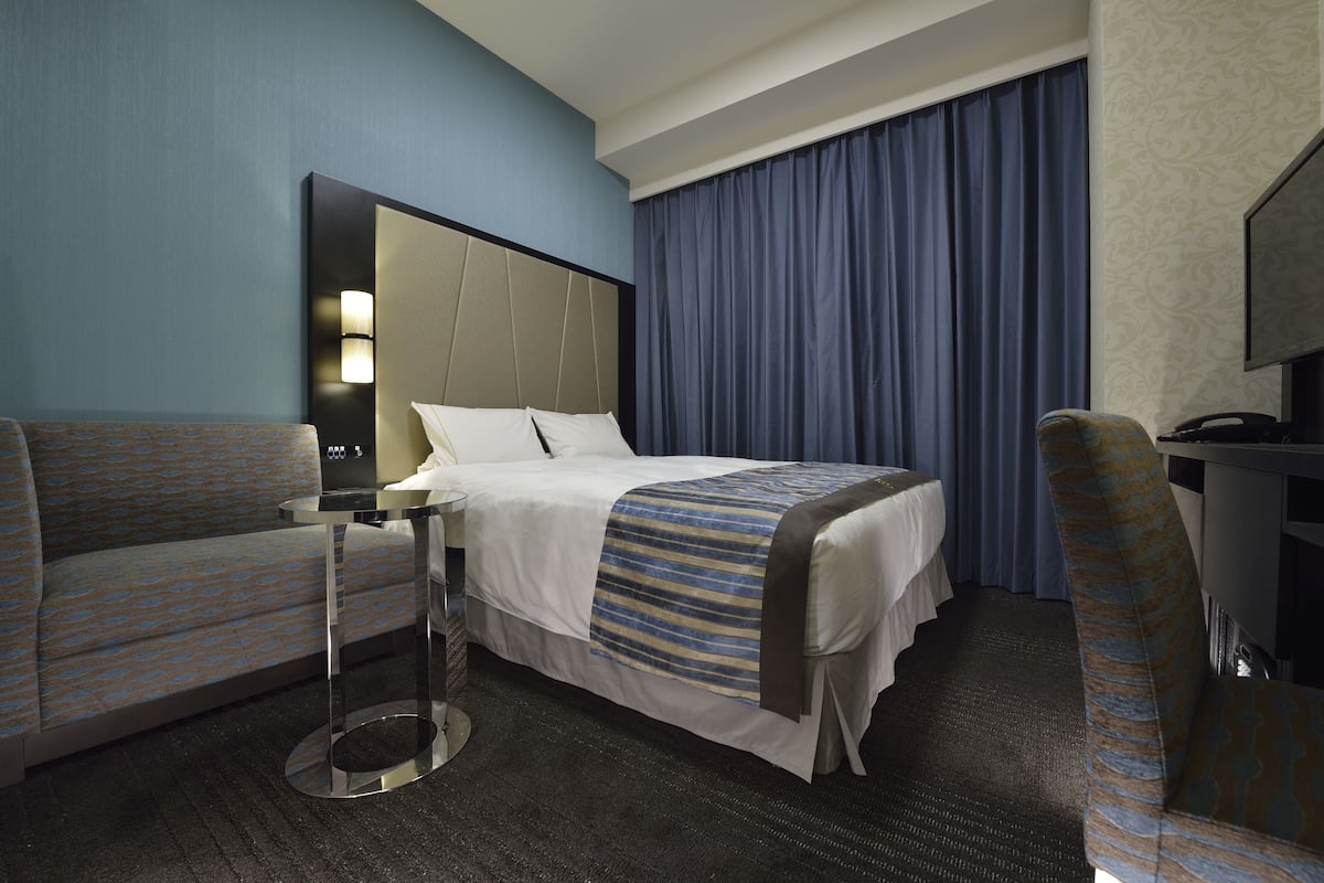 Une chambre d’hôtel équipée d’un lit, d’un canapé, d’un bureau et d’une télévision.