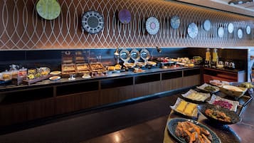Un buffet proposant une variété de plats et un mur orné de nombreuses horloges.