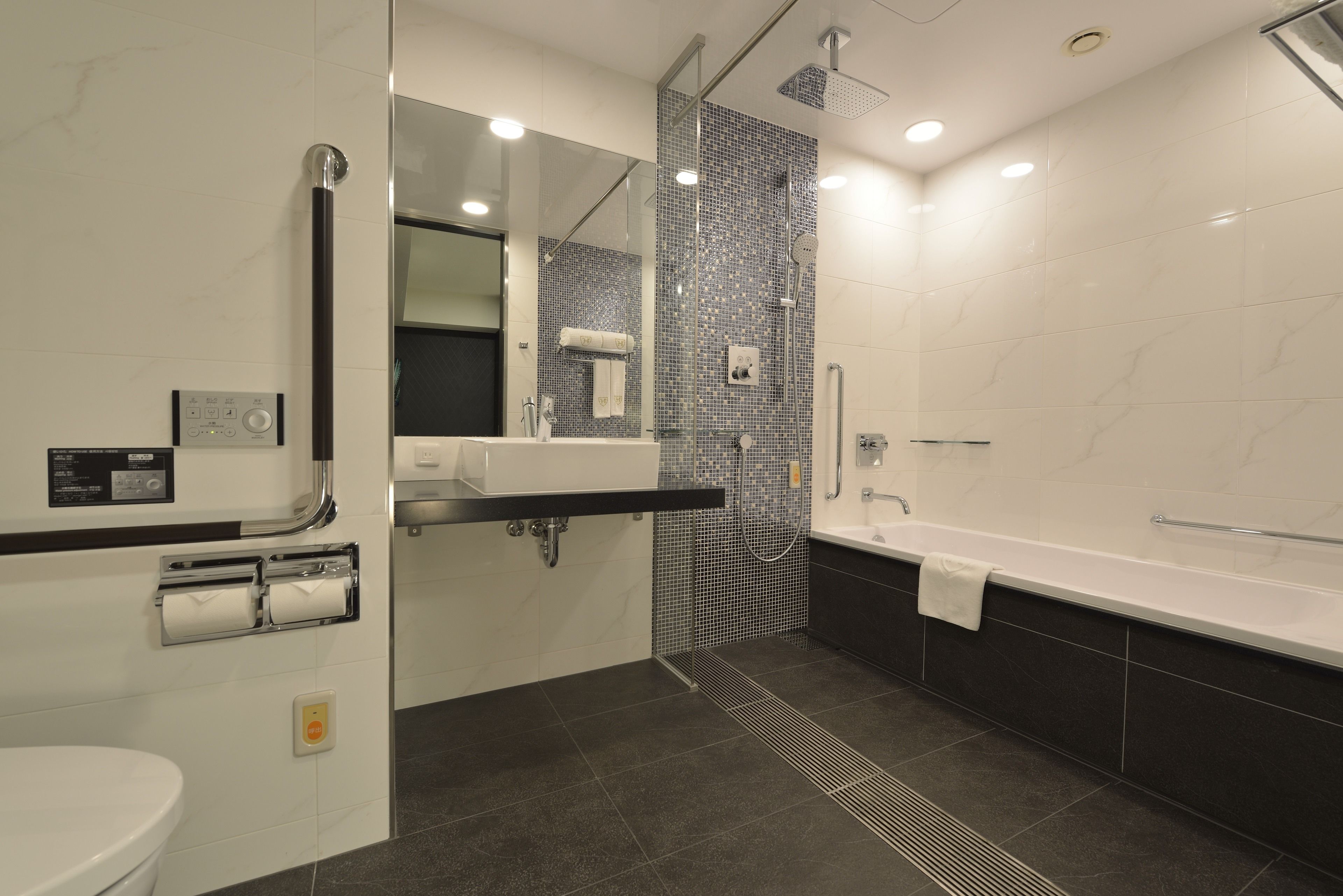 A modern bathroom with a toilet, sink, and bathtub.