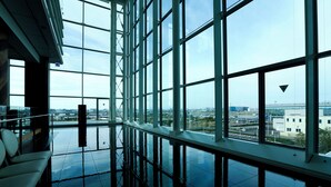 A spacious lobby with large windows offering views of a cityscape. - The Royal Park Hotel Tokyo Haneda Airport Terminal 3 (Tokyo)