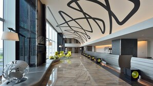 A modern lobby with a curved bench, a globe sculpture, and a unique ceiling design. - The Royal Park Hotel Tokyo Haneda Airport Terminal 3 (Tokyo)