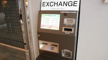 A currency exchange machine with a sign indicating foreign currency exchange rates.