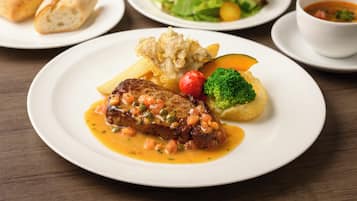 A plate with a steak, vegetables, and a side of bread.