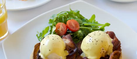 Une assiette de petit-déjeuner avec des œufs, du bacon et des légumes verts.