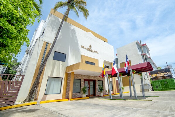 A hotel with a modern facade, a prominent entrance, and a flag display.