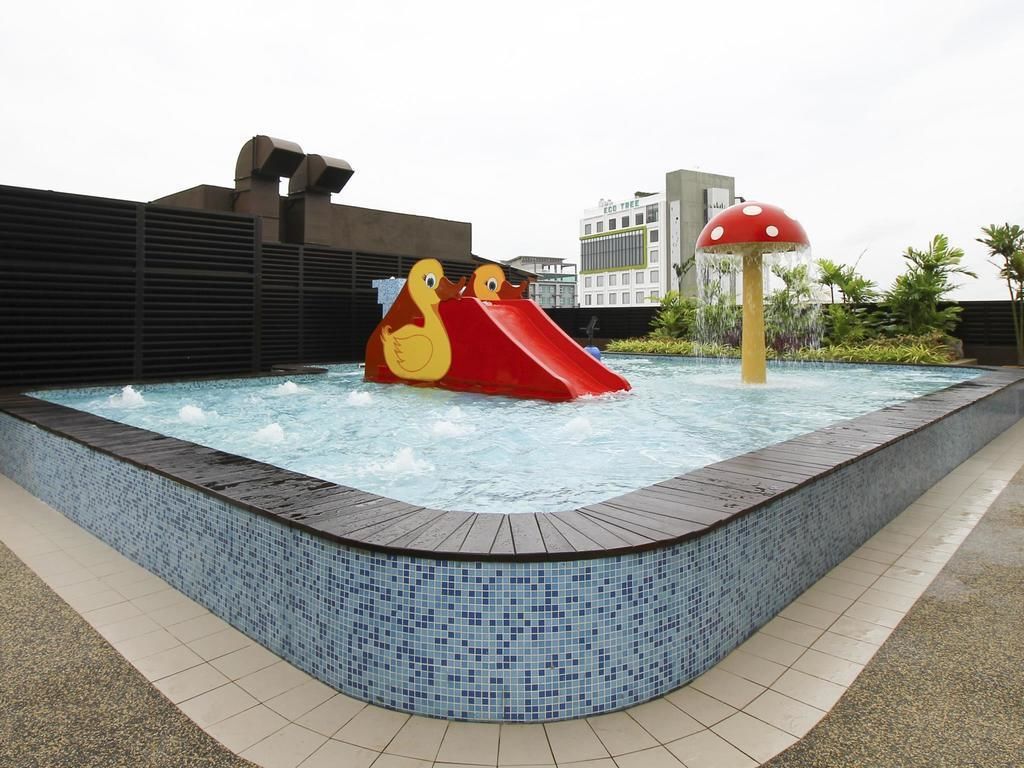 A swimming pool with a slide and a mushroom-shaped water feature.