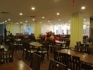 Guests can dine and socialize in this well-lit dining area with tables and chairs.