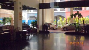 A hotel lobby with a reception desk, seating area, and a view of the street outside. - La Boss Hotel (Malacca City)
