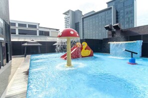 Relax by the pool surrounded by a deck and enjoy the water play structure with a mushroom-shaped feature and a duck.