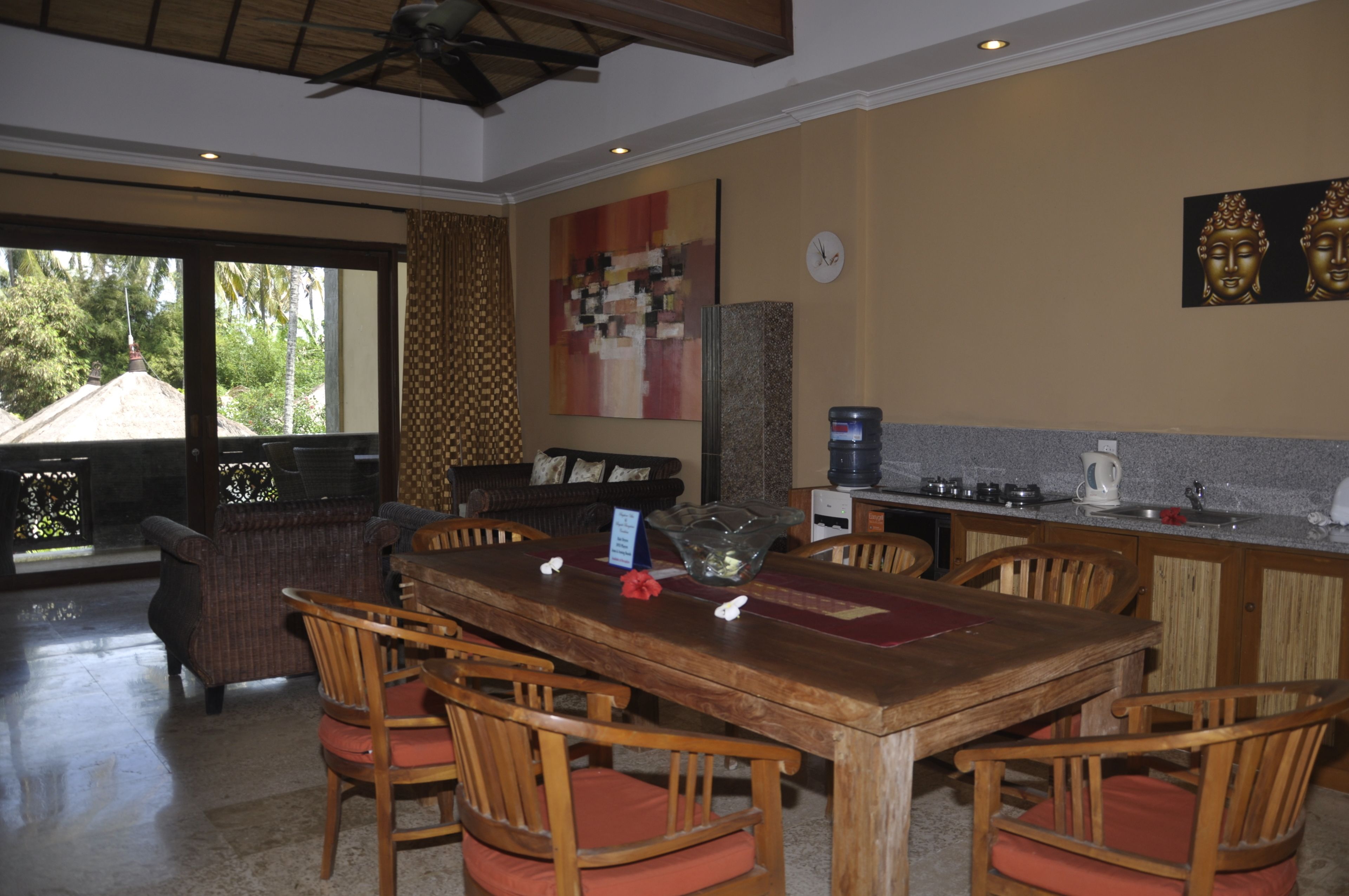 A dining area with a wooden table and chairs, a coffee machine, and a view of the outdoors.