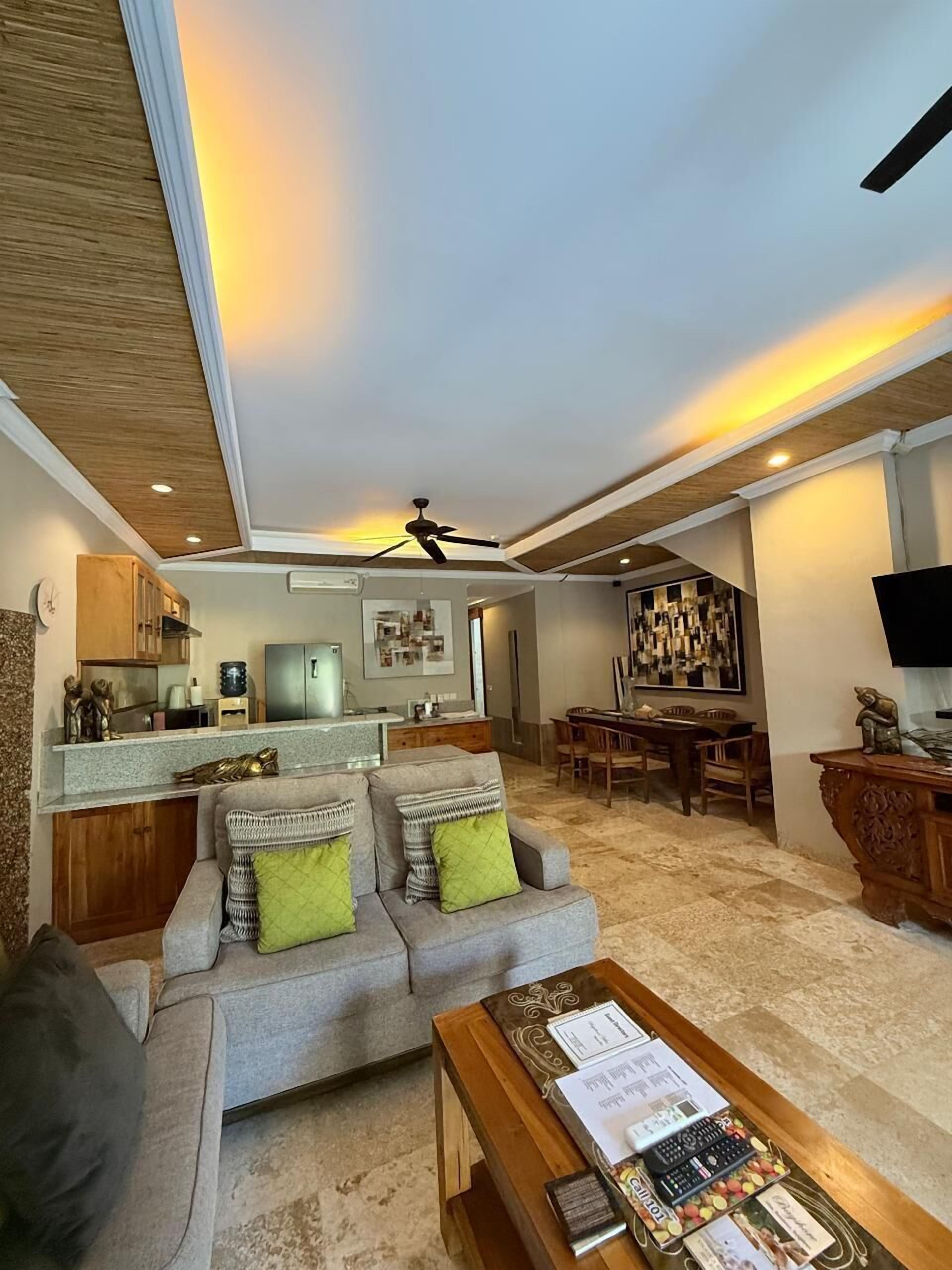 A living room with a sofa, coffee table, and a dining area with chairs and a table.