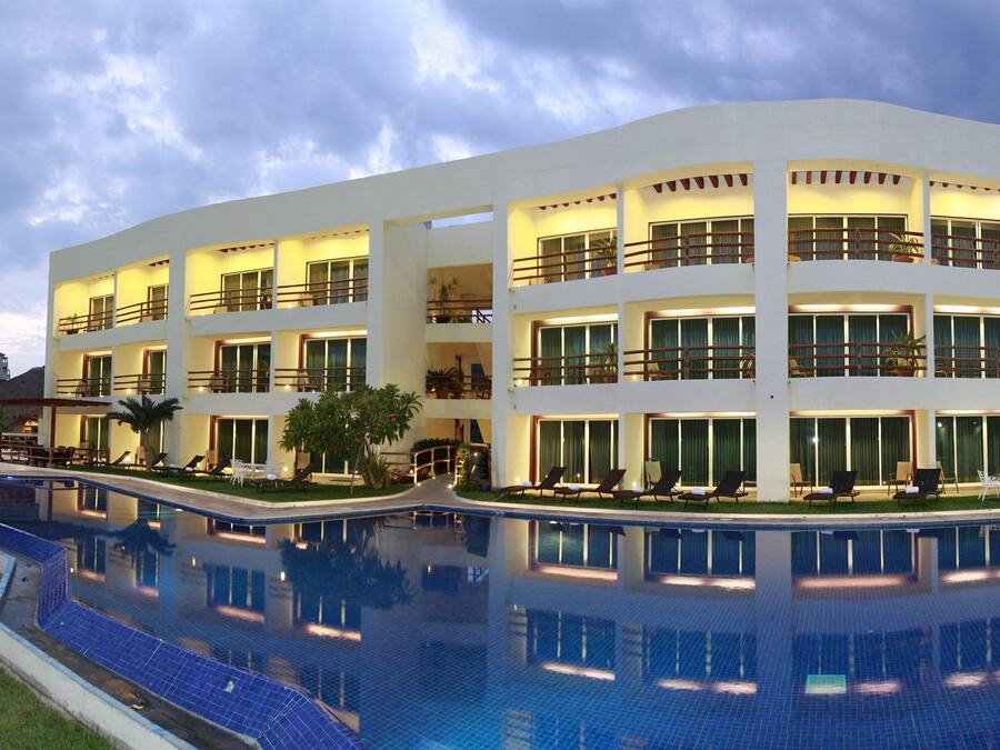 Ett hotell med flera våningar, en swimmingpool, utomhusplats och balkonger.