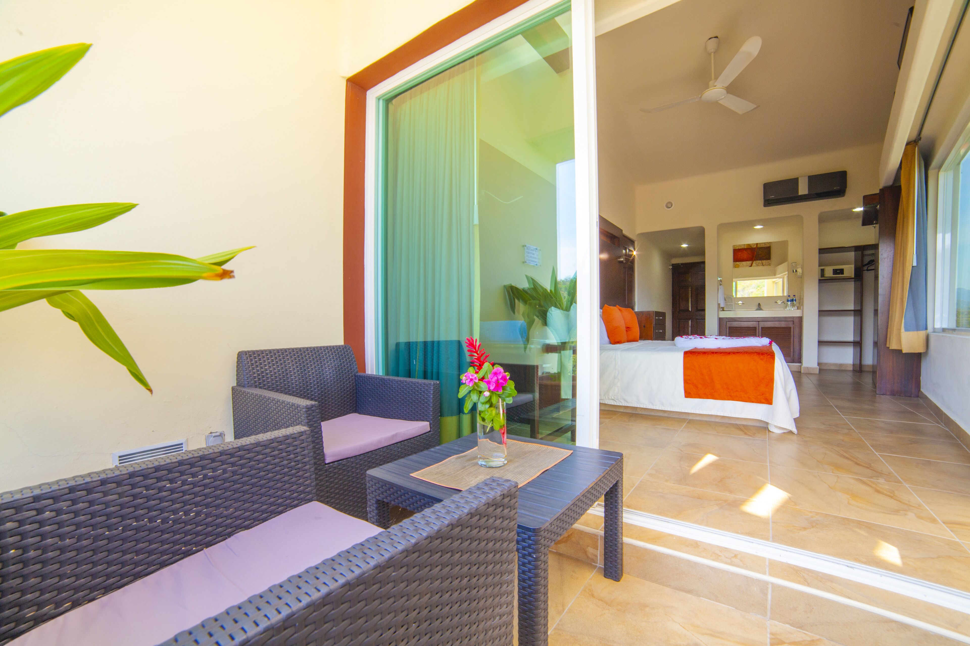 Una habitación de hotel moderna con balcón, zona de comedor y cocina.