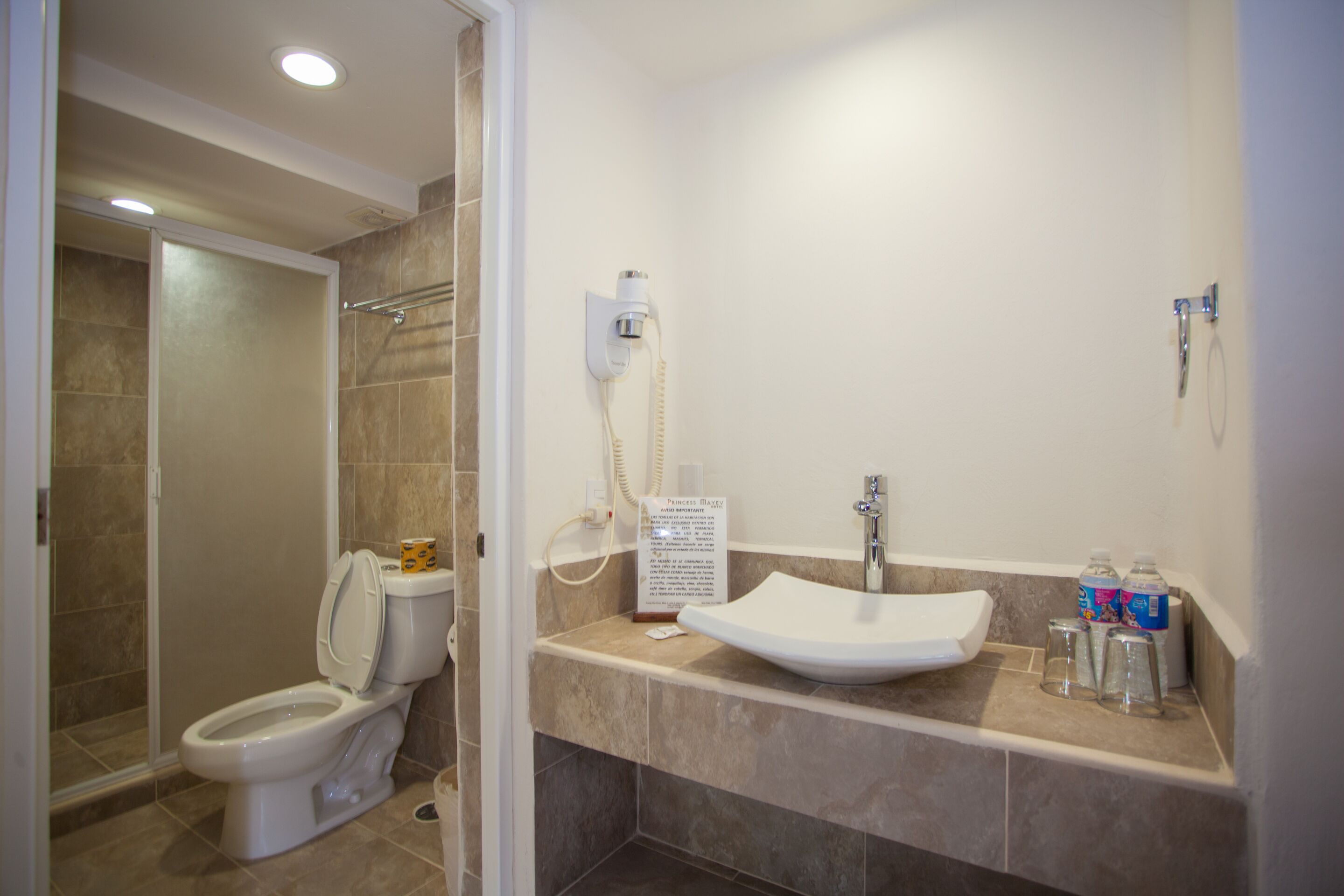 Une salle de bain avec des toilettes, un lavabo et une douche.