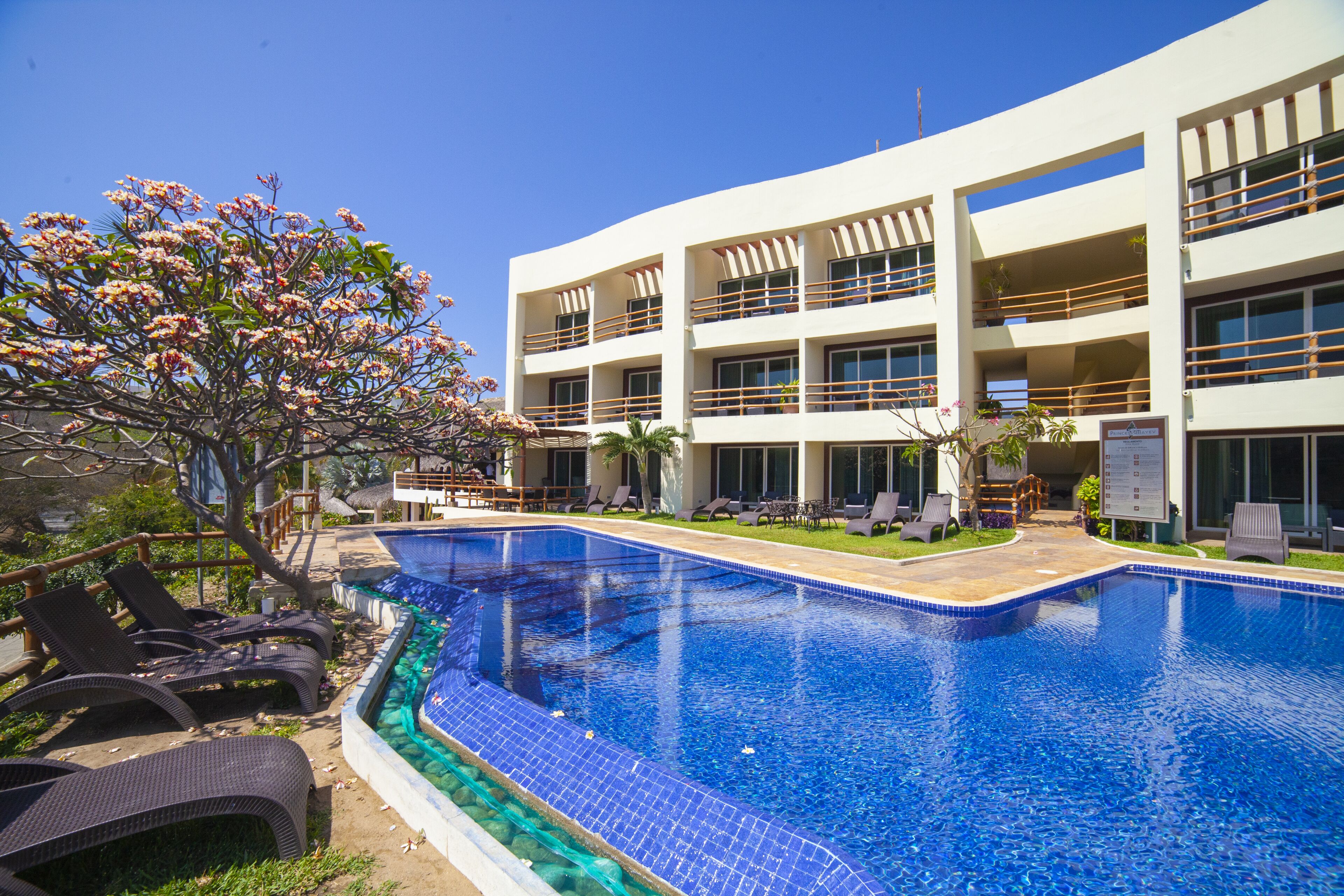 Un hôtel moderne doté d’une piscine, de nombreux balcons et d’espaces extérieurs aménagés pour se détendre.