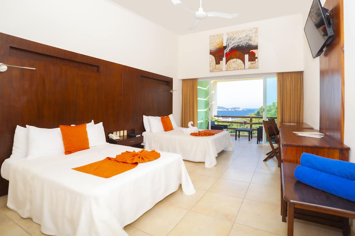 A hotel room with two beds, a dining area, and a TV.
