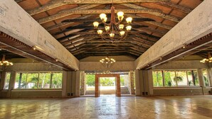 Ein geräumiger Saal mit hoher Decke, großen Fenstern und einem zentralen Kronleuchter.
