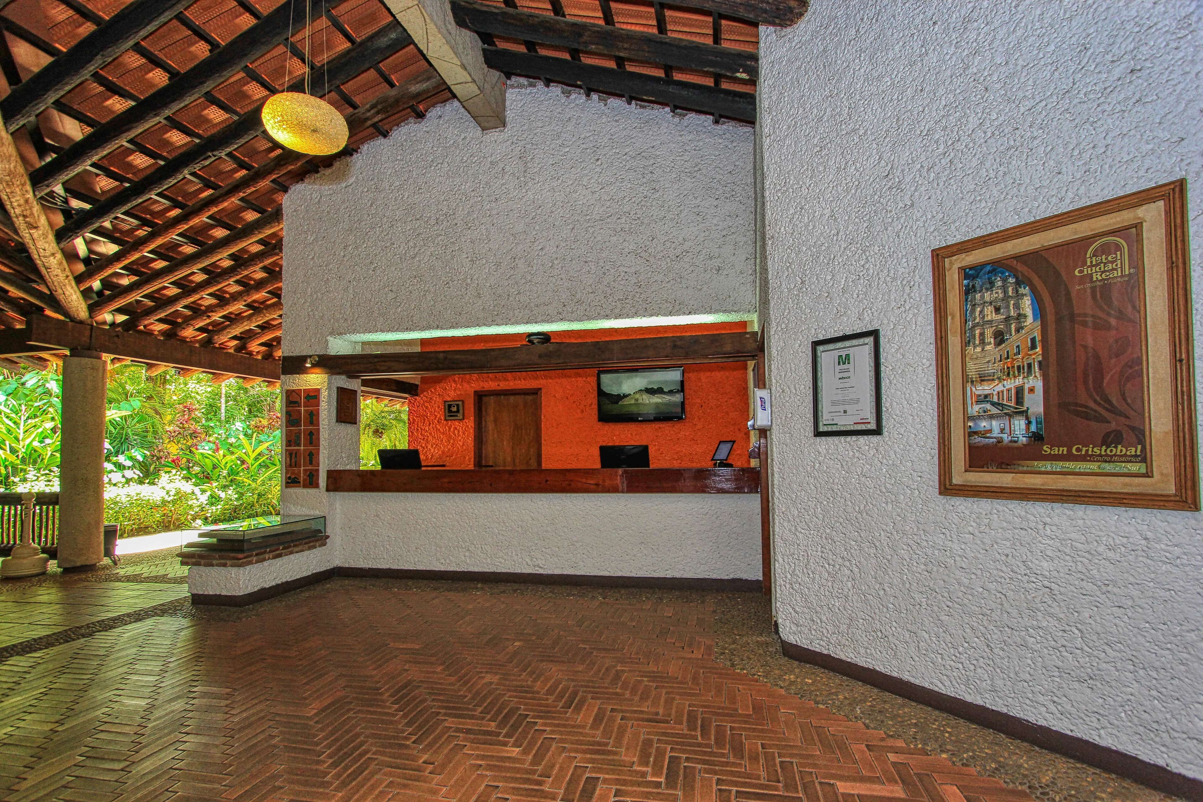 A reception area with a wooden ceiling, a reception desk, and a poster on the wall.