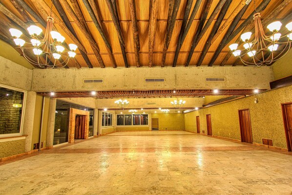 A spacious hall with a high ceiling, wooden beams, and chandeliers. - Hotel Ciudad Real Palenque (Palenque)