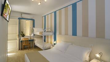 A hotel room with a bunk bed, a desk with a chair, a television, and a bedside lamp.