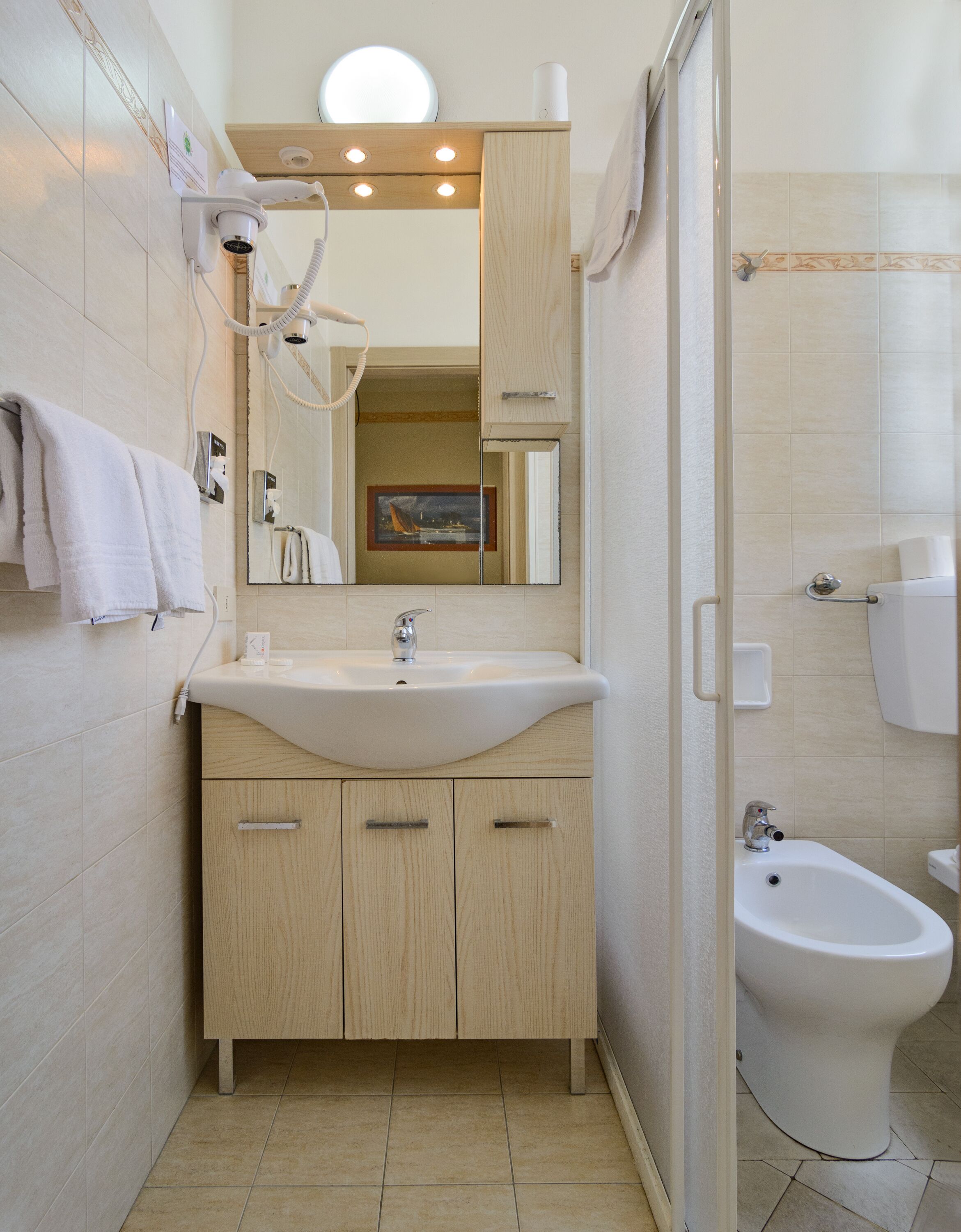 Une salle de bain moderne équipée d’un lavabo, d’un meuble-lavabo, d’un miroir et d’un bidet.