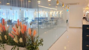 Un espacio de oficina moderno con paredes de cristal, varias estaciones de trabajo y una zona de recepción.
