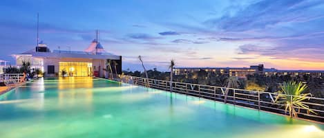 Una piscina al aire libre, sombrillas, tumbonas
