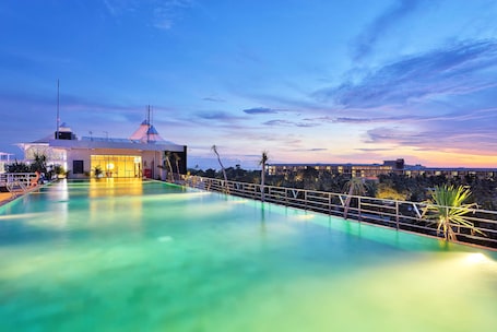 Una piscina al aire libre, sombrillas, sillones reclinables de piscina