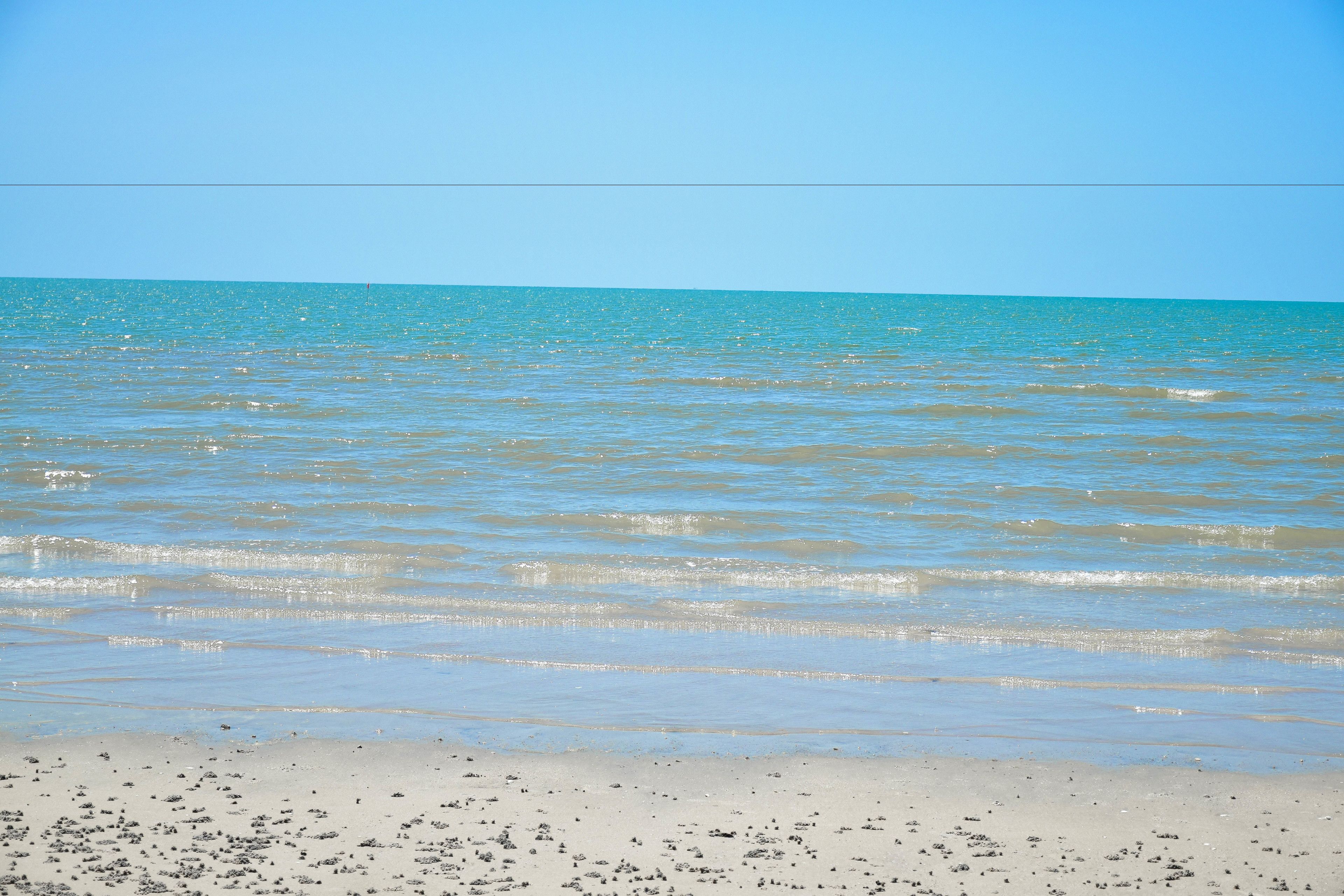 Una playa con aguas cristalinas y una orilla arenosa.