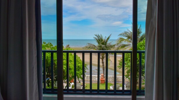 A balcony with a view of the beach and palm trees. - Sea Memories White Sand Beach Hotel (Hua Hin)
