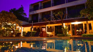 A hotel with a swimming pool, outdoor seating, and a two-story building with balconies. - Sea Memories White Sand Beach Hotel (Hua Hin)