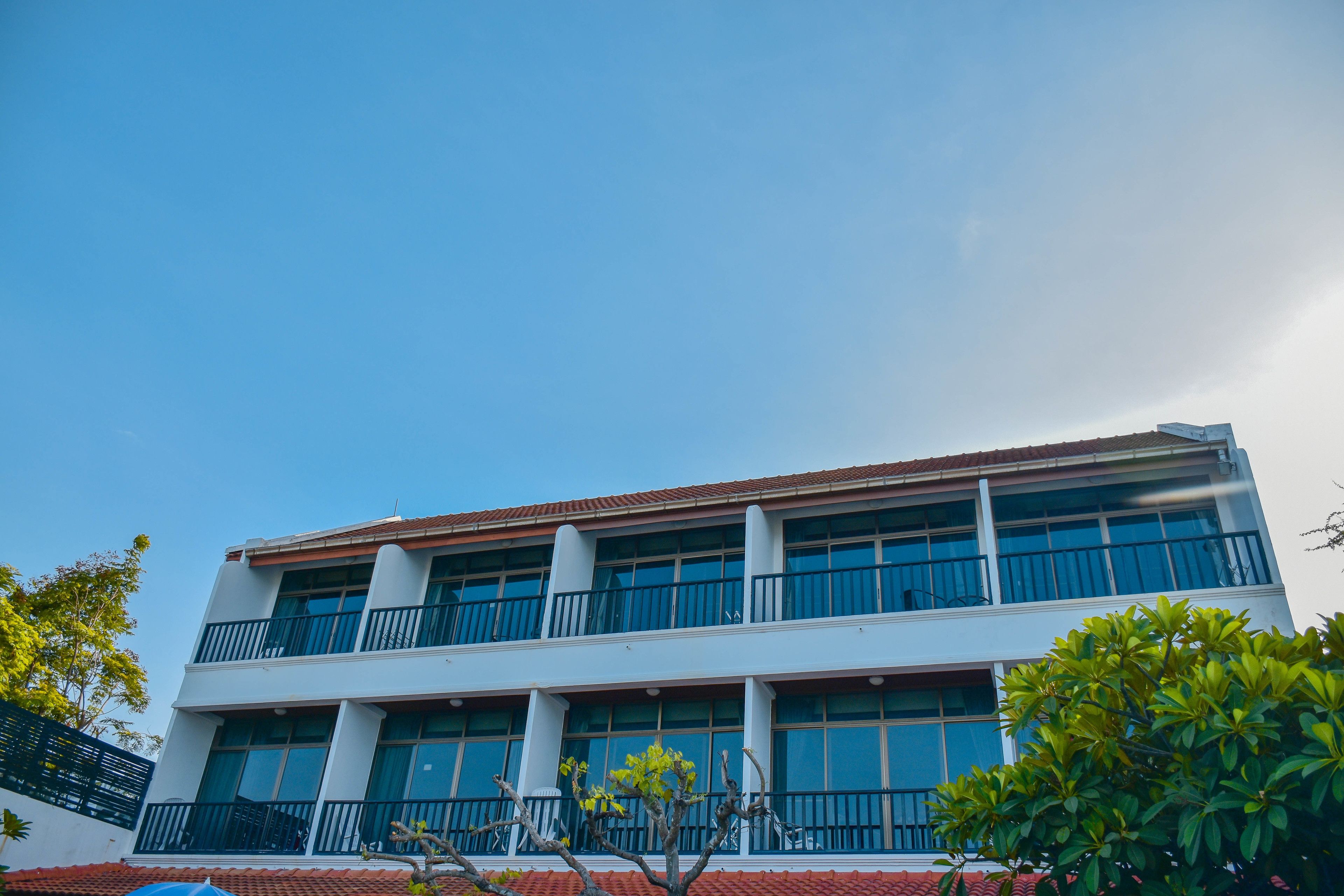 A multi-story building with a flat roof, large windows, and balconies.