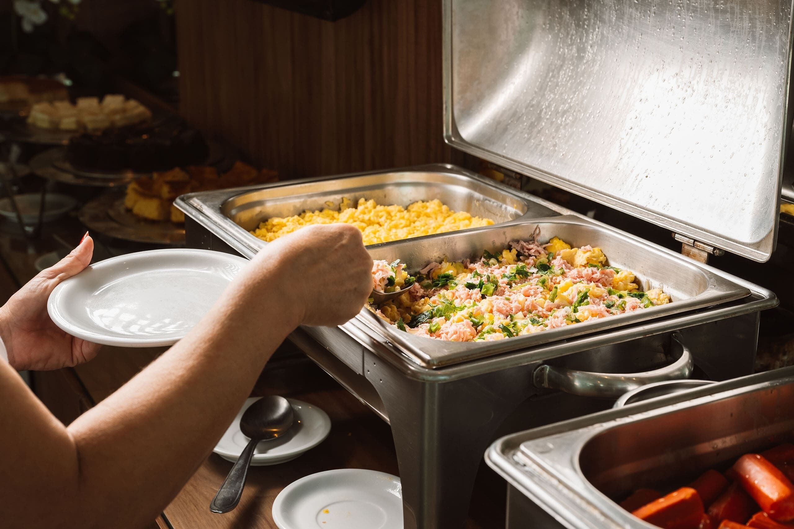 Un bufé con diversos platos, entre ellos arroz y una ensalada de mariscos.