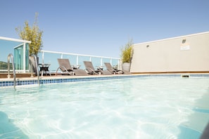 Una piscina al aire libre, tumbonas