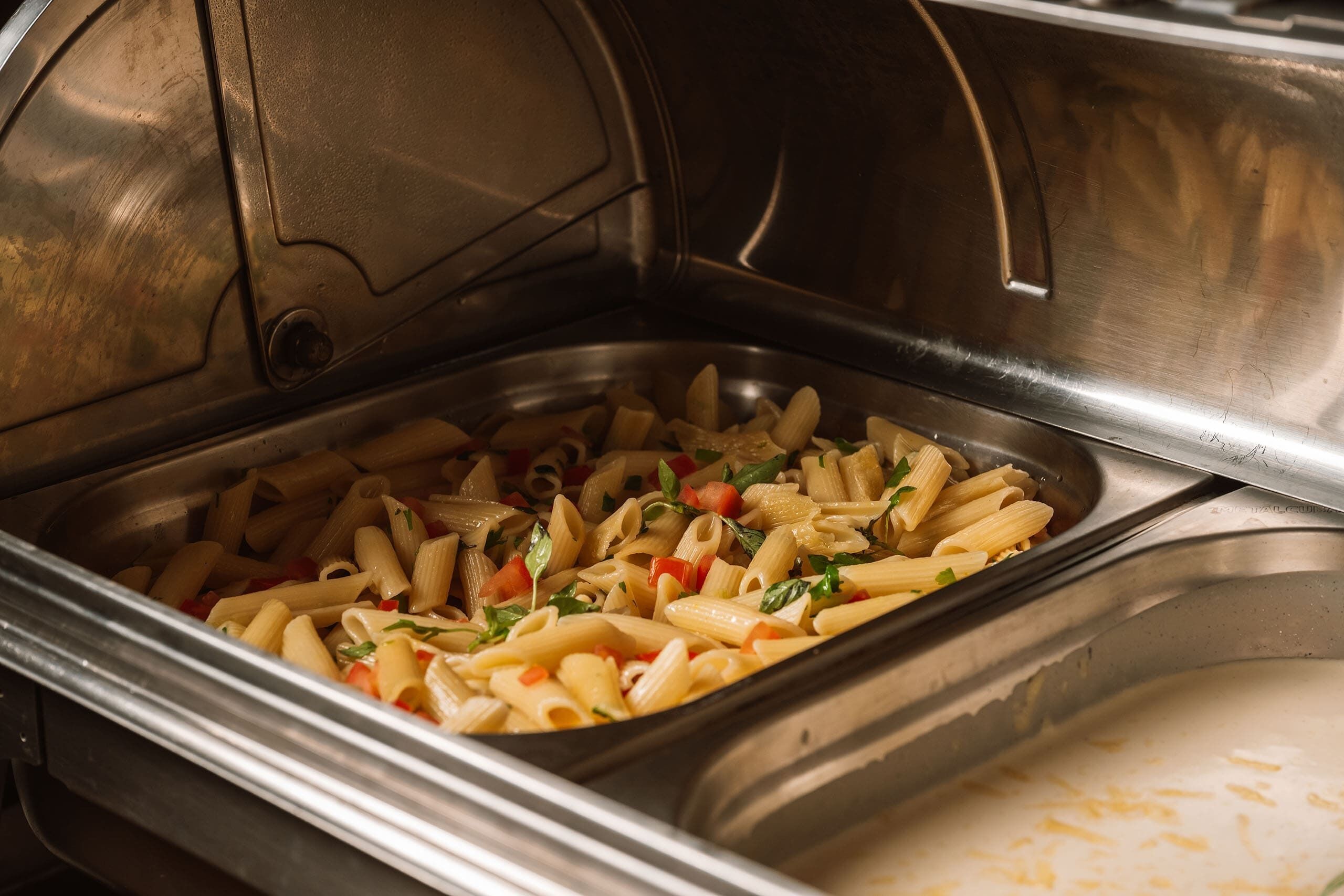 Un bufé con platos de pasta.