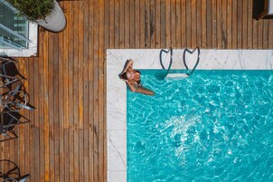 Una piscina al aire libre, sillones reclinables de piscina