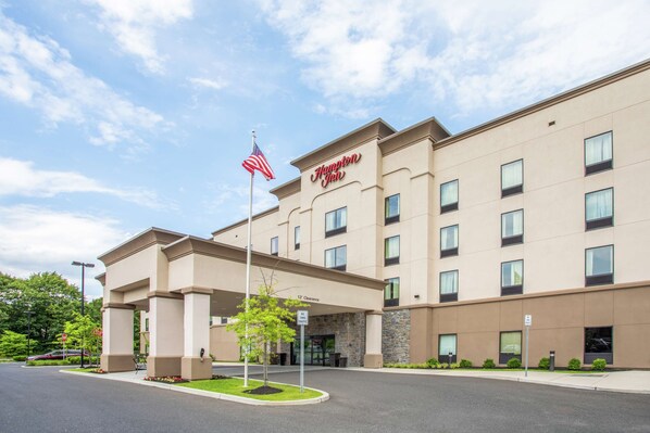 A Hampton Inn hotel with a clear entrance, American flag, and a sign indicating a 12-car garage. - Hampton Inn Philadelphia/Voorhees (Voorhees)