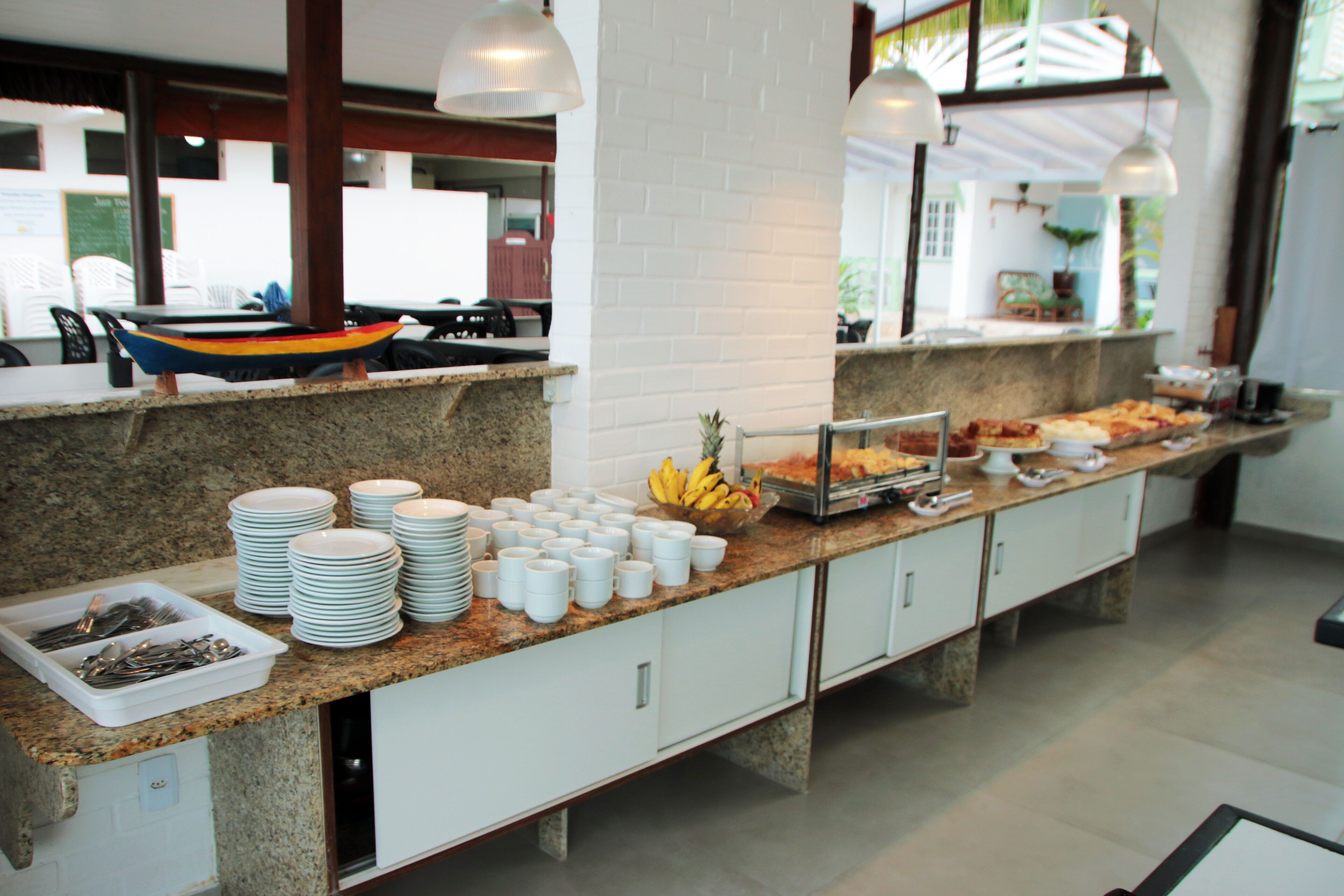 A buffet setup with plates, bowls, and utensils.
