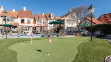 Enjoy a round of golf on our meticulously maintained course, surrounded by traditional buildings with red-tiled roofs.