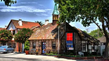 Traditional hotel with a charming mix of brick and timber framing, set amidst lush greenery.