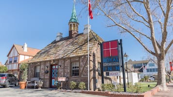 A historic building with a traditional facade, a prominent clock tower, and a sign indicating it is a hotel.
