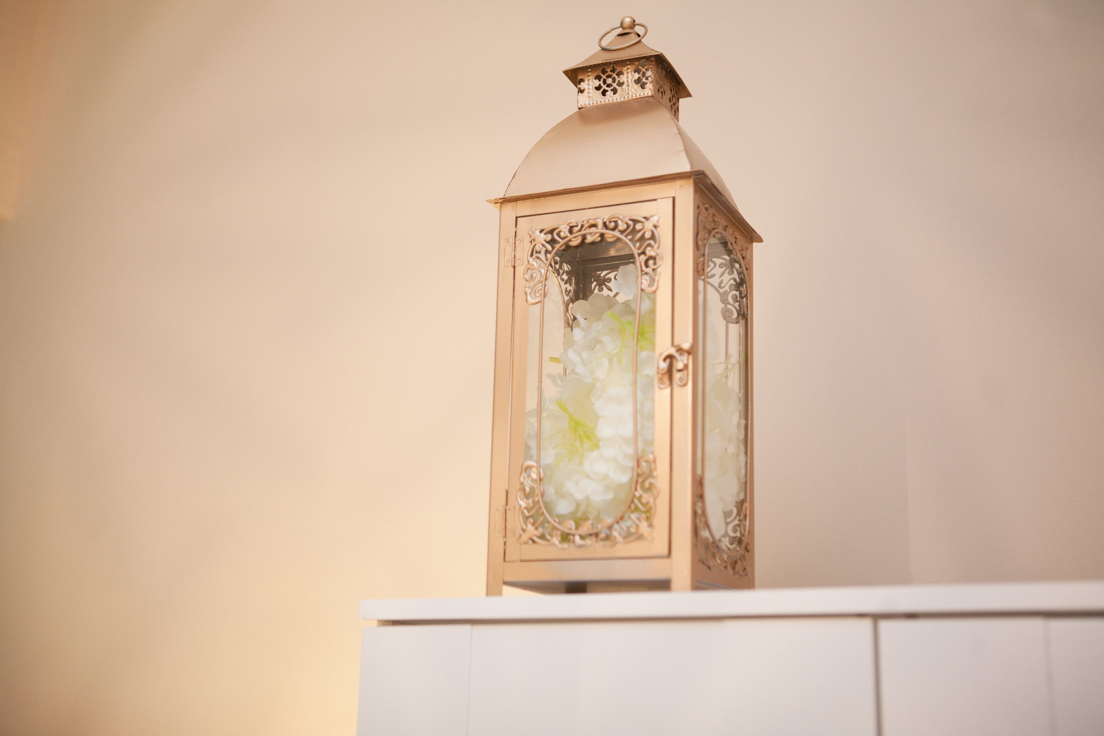 A white cabinet with a decorative lantern on top.