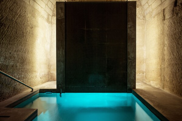A swimming pool with a dark wall and a metal handrail on one side. - La Maison d'Uzes (Uzès)