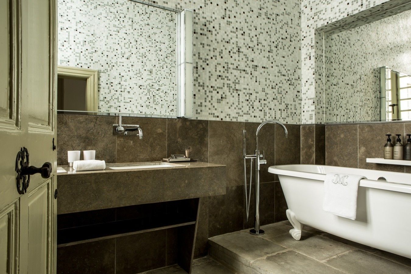 A bathroom with a freestanding bathtub, a sink with a mirror above it, and a shower area.